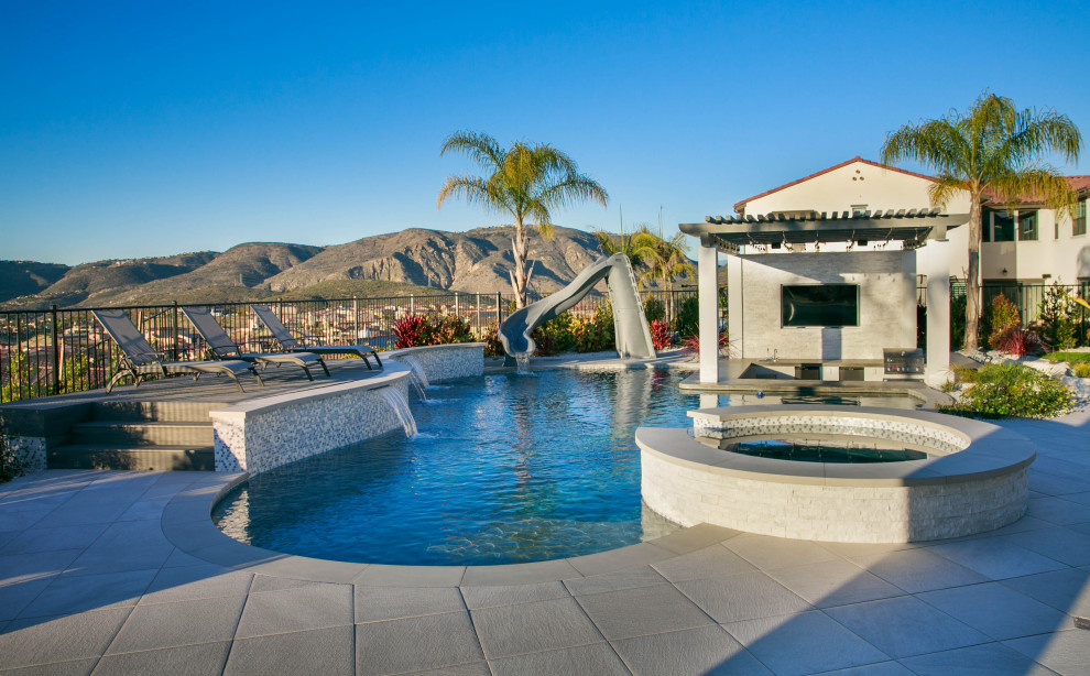 This is an example of a medium sized traditional back custom shaped natural swimming pool in San Diego with a pool house and tiled flooring.