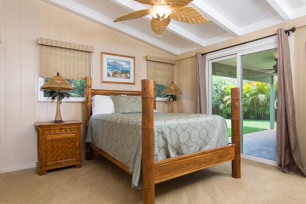 Mid-sized tropical master bedroom in Hawaii with beige walls, carpet, no fireplace and beige floor.