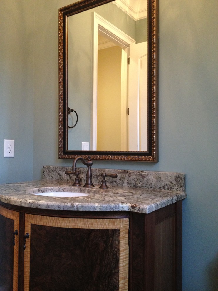 Design ideas for a mid-sized traditional powder room in Raleigh with an undermount sink, furniture-like cabinets, medium wood cabinets, granite benchtops, blue walls and medium hardwood floors.