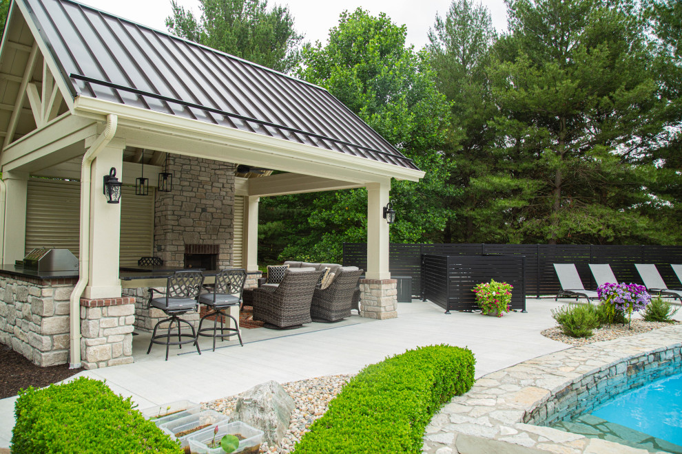 Стильный дизайн: естественный бассейн среднего размера на заднем дворе в классическом стиле с покрытием из бетонных плит - последний тренд