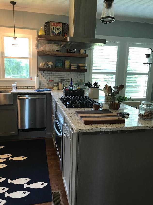 Photo of a mid-sized country u-shaped open plan kitchen in Other with a farmhouse sink, shaker cabinets, grey cabinets, quartz benchtops, white splashback, subway tile splashback, stainless steel appliances, medium hardwood floors, a peninsula and brown floor.