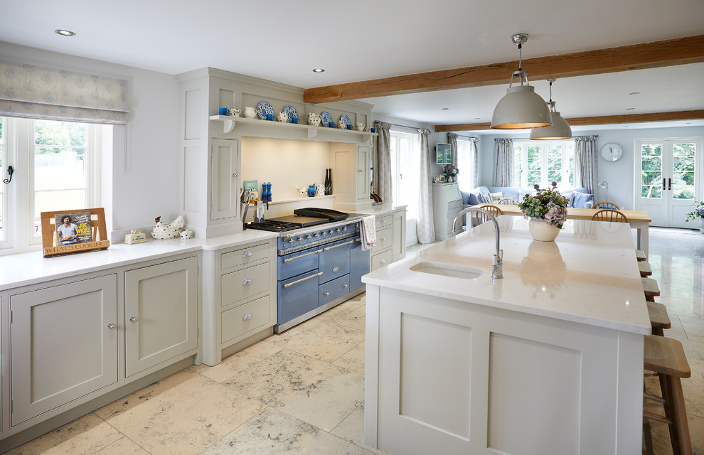 Photo of an expansive country l-shaped open plan kitchen in Other with shaker cabinets, grey cabinets, quartzite benchtops, coloured appliances, limestone floors, with island, an undermount sink, beige floor and grey splashback.
