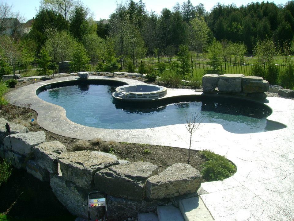 Inspiration for a large craftsman backyard stone and custom-shaped natural hot tub remodel
