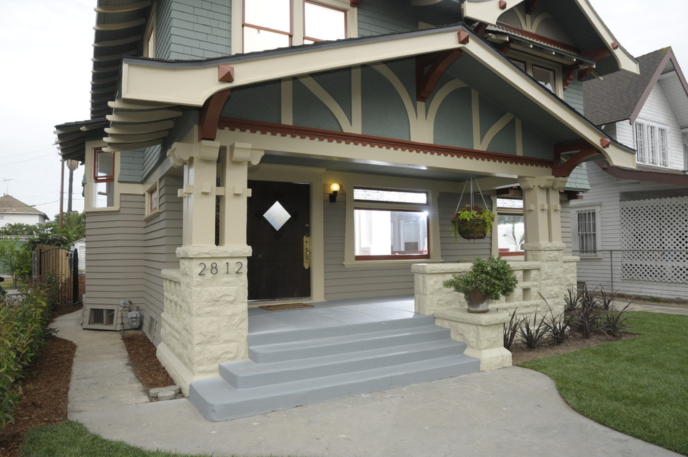 Photo of a large arts and crafts front yard verandah in Los Angeles with a roof extension and concrete slab.