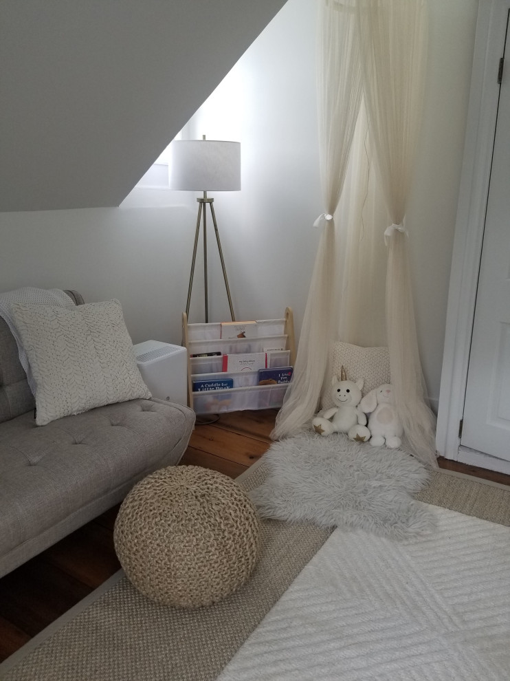 Immagine di una cameretta per neonata country di medie dimensioni con pareti bianche, pavimento in legno massello medio e pavimento marrone