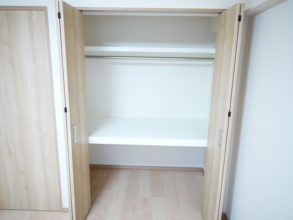 Inspiration for an asian built-in wardrobe in Tokyo with light hardwood floors.