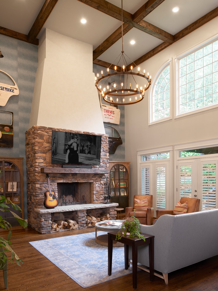 Inspiration for a large transitional open concept family room in Nashville with blue walls, dark hardwood floors, a standard fireplace, a stone fireplace surround, a wall-mounted tv and brown floor.