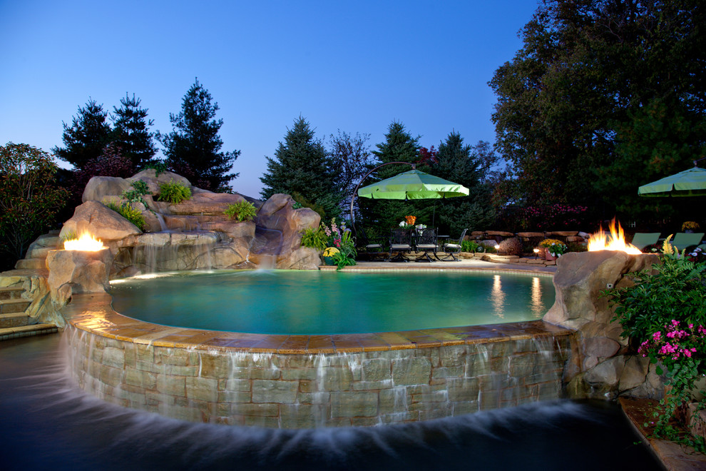 Inspiration for a tropical custom-shaped natural pool in Cincinnati with a water slide.