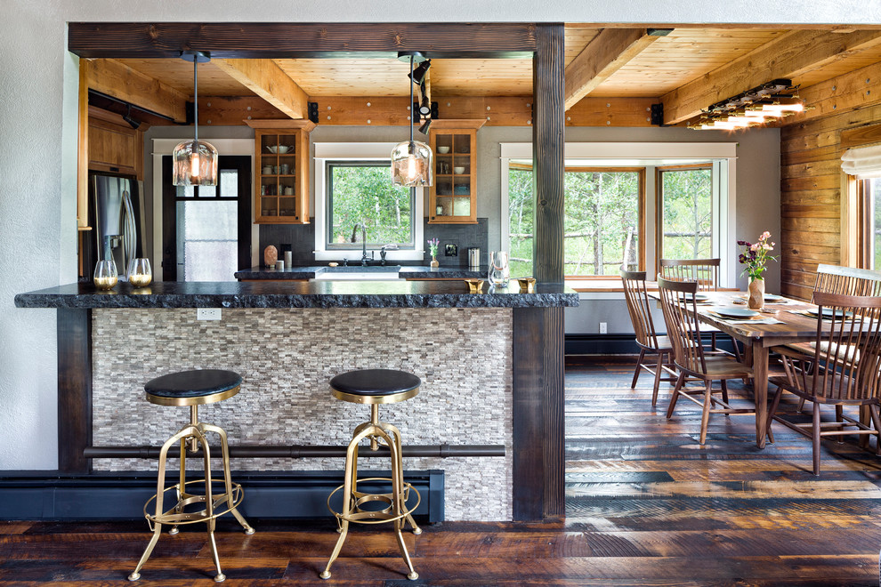 Mid-sized mountain style u-shaped dark wood floor and brown floor eat-in kitchen photo in Denver with a farmhouse sink, medium tone wood cabinets, granite countertops, gray backsplash, ceramic backsplash and a peninsula