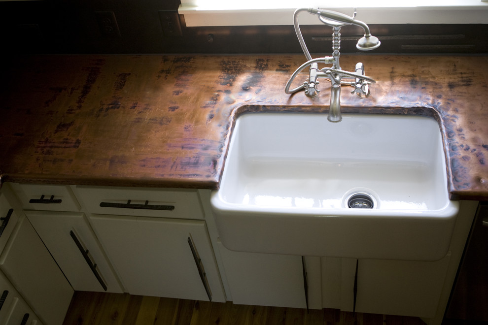 Photo of a traditional kitchen in Charlotte with a farmhouse sink and copper benchtops.