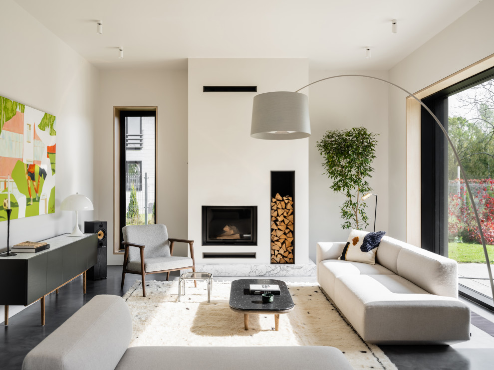 Стильный дизайн: открытая, объединенная гостиная комната в современном стиле с стандартным камином и фасадом камина из штукатурки без телевизора - последний тренд