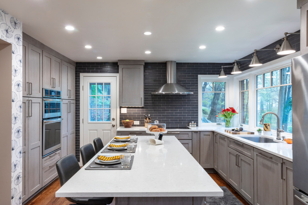 Eat-in kitchen - contemporary u-shaped medium tone wood floor and brown floor eat-in kitchen idea with an undermount sink, shaker cabinets, gray cabinets, quartz countertops, gray backsplash, ceramic backsplash, stainless steel appliances, an island and gray countertops