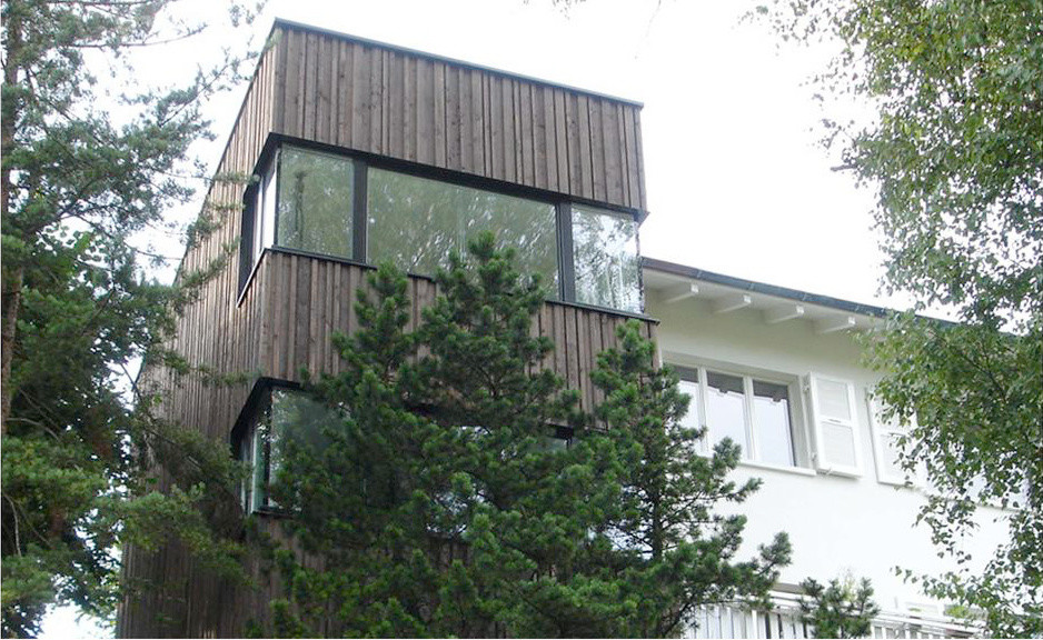 Foto della villa grande marrone contemporanea a tre piani con rivestimento in legno e tetto piano