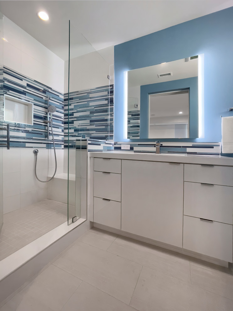Стильный дизайн: маленькая ванная комната в стиле модернизм с плоскими фасадами, белыми фасадами, душем в нише, раздельным унитазом, синей плиткой, керамогранитной плиткой, синими стенами, полом из керамогранита, душевой кабиной, врезной раковиной, столешницей из искусственного кварца, белым полом, душем с распашными дверями, белой столешницей, фартуком, тумбой под одну раковину и встроенной тумбой для на участке и в саду - последний тренд