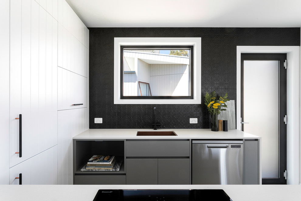 Inspiration for a contemporary u-shaped kitchen in Brisbane with an undermount sink, flat-panel cabinets, white cabinets, black splashback, stainless steel appliances, a peninsula and white benchtop.