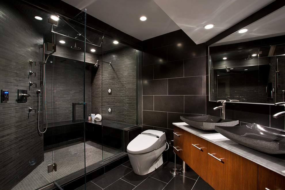 This is an example of a contemporary bathroom in New York with a vessel sink, black walls and black floor.