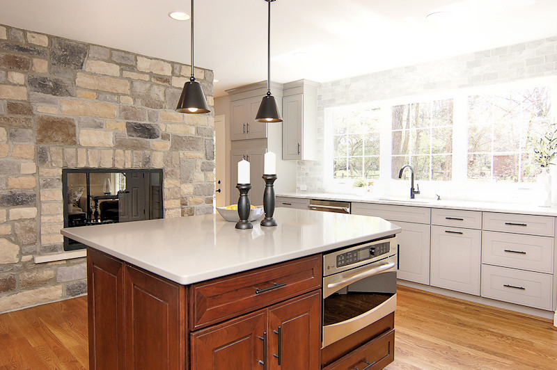 Example of a large transitional medium tone wood floor kitchen design in Cincinnati with a single-bowl sink, shaker cabinets, gray cabinets, marble countertops, white backsplash, stone tile backsplash, stainless steel appliances, beige walls and an island