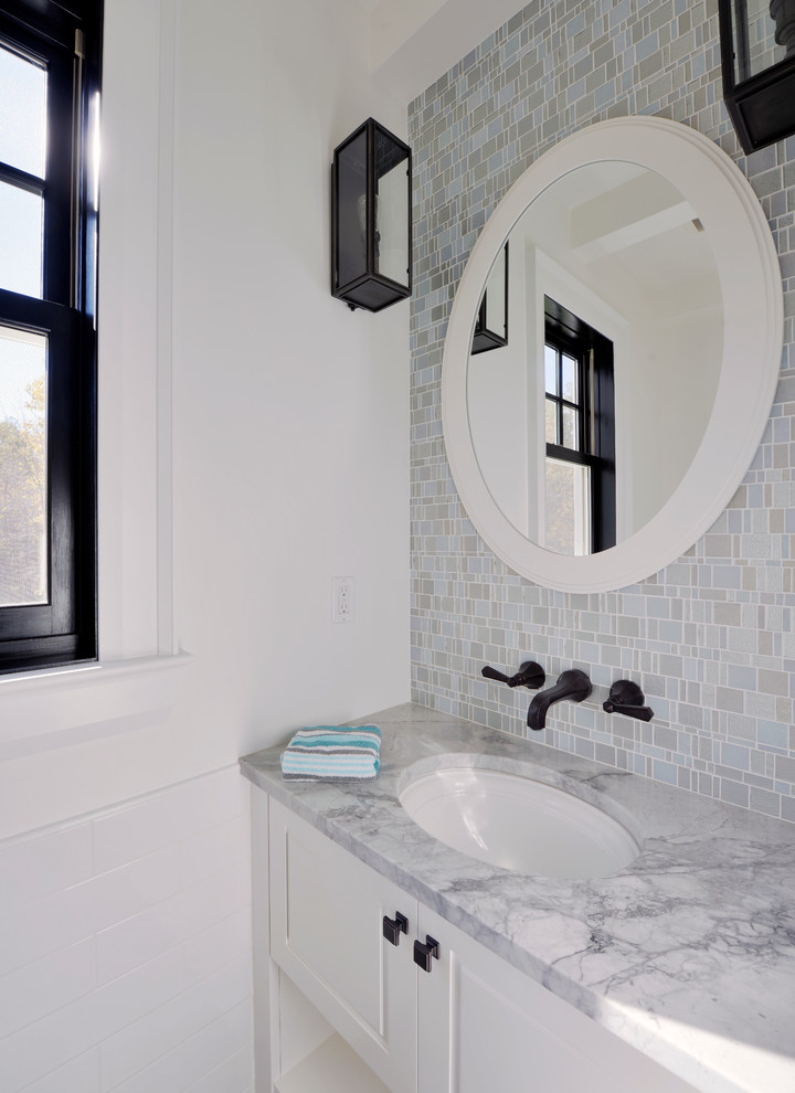 Design ideas for a mid-sized transitional powder room in Toronto with shaker cabinets, white cabinets, blue tile, gray tile, mosaic tile, white walls, porcelain floors, an undermount sink, marble benchtops and grey benchtops.