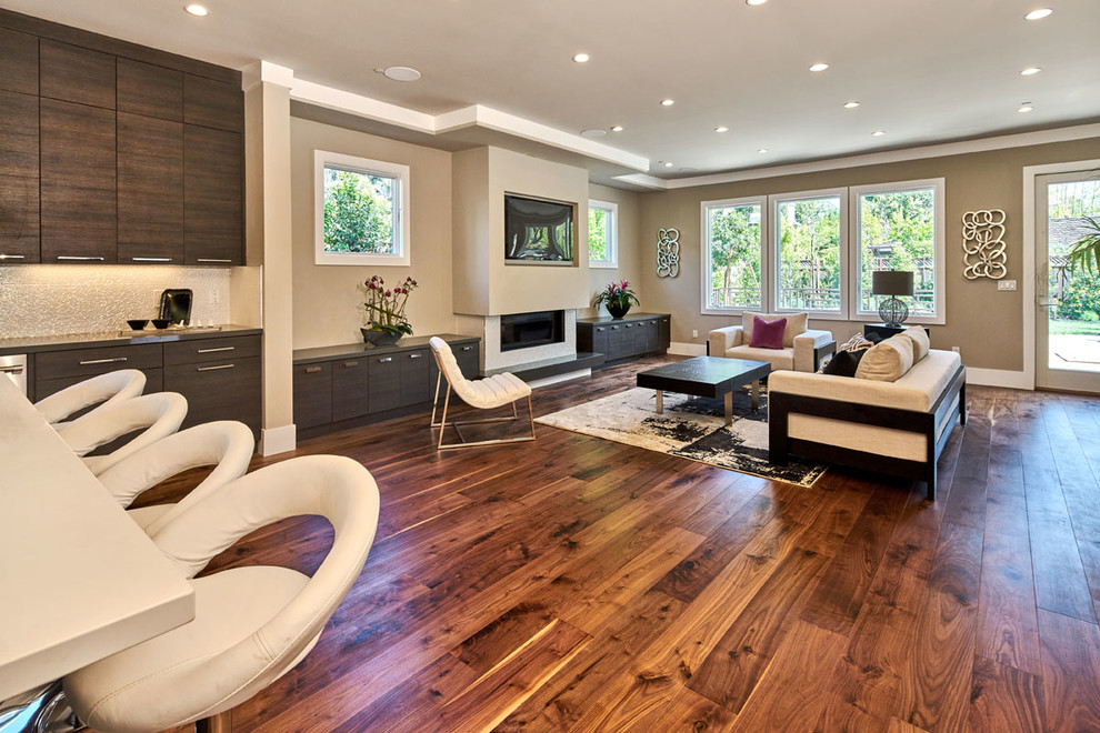 Inspiration for an expansive contemporary open concept family room in San Francisco with beige walls, dark hardwood floors, a ribbon fireplace, a stone fireplace surround and a built-in media wall.