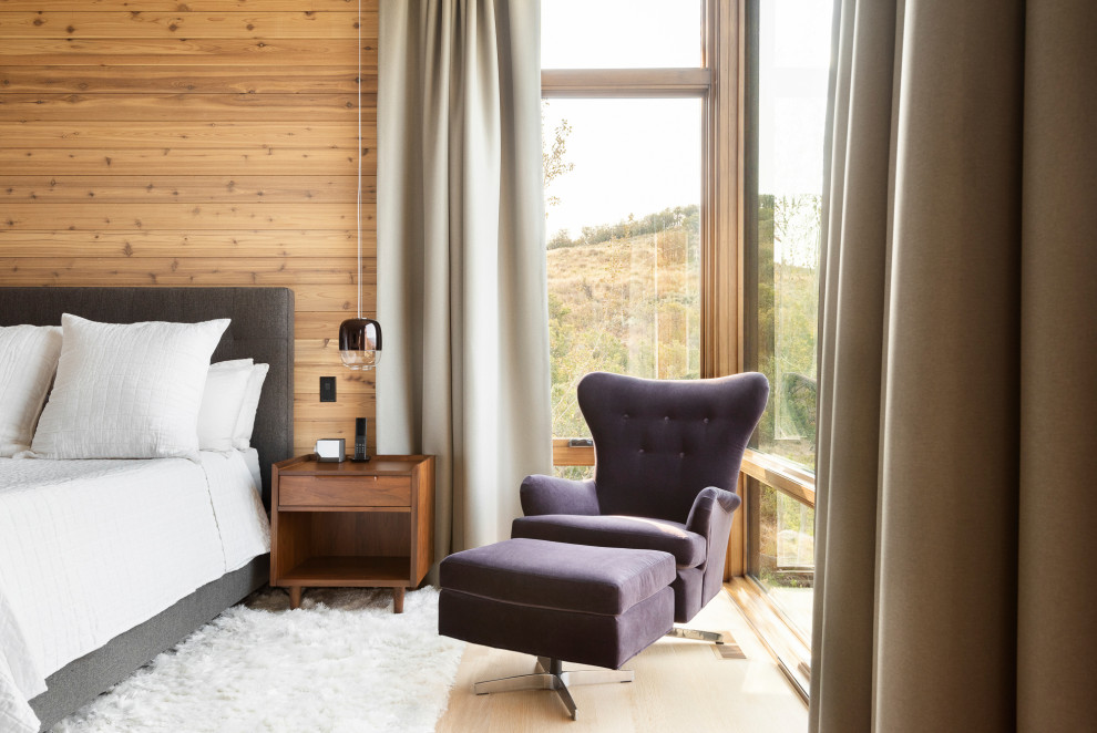 Cette image montre une chambre parentale minimaliste en bois avec parquet clair.
