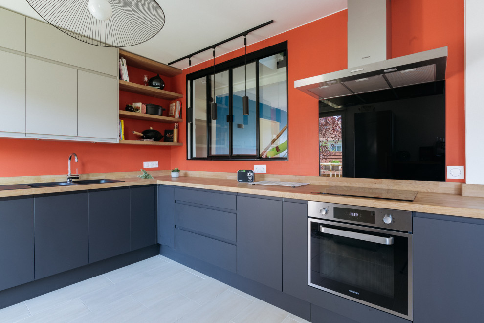Cette image montre une cuisine bohème en L avec un plan de travail en bois, une crédence orange, un sol en carrelage de céramique et un sol blanc.