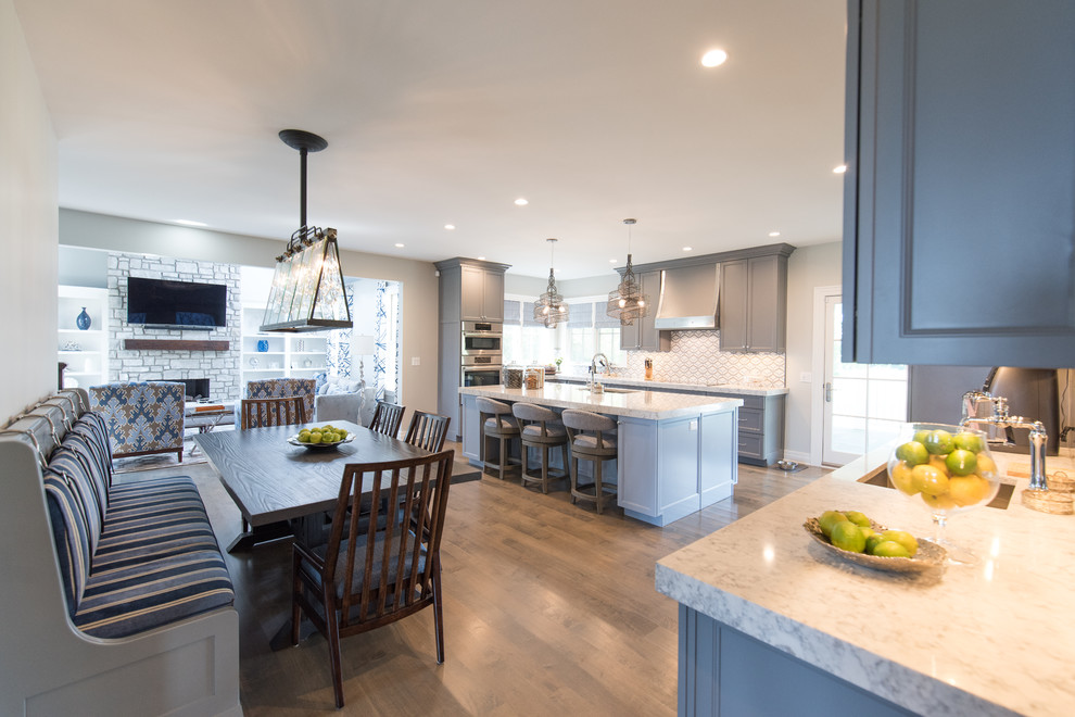 Eat-in kitchen - large transitional medium tone wood floor eat-in kitchen idea with a single-bowl sink, shaker cabinets, gray cabinets, quartz countertops, multicolored backsplash, marble backsplash and paneled appliances