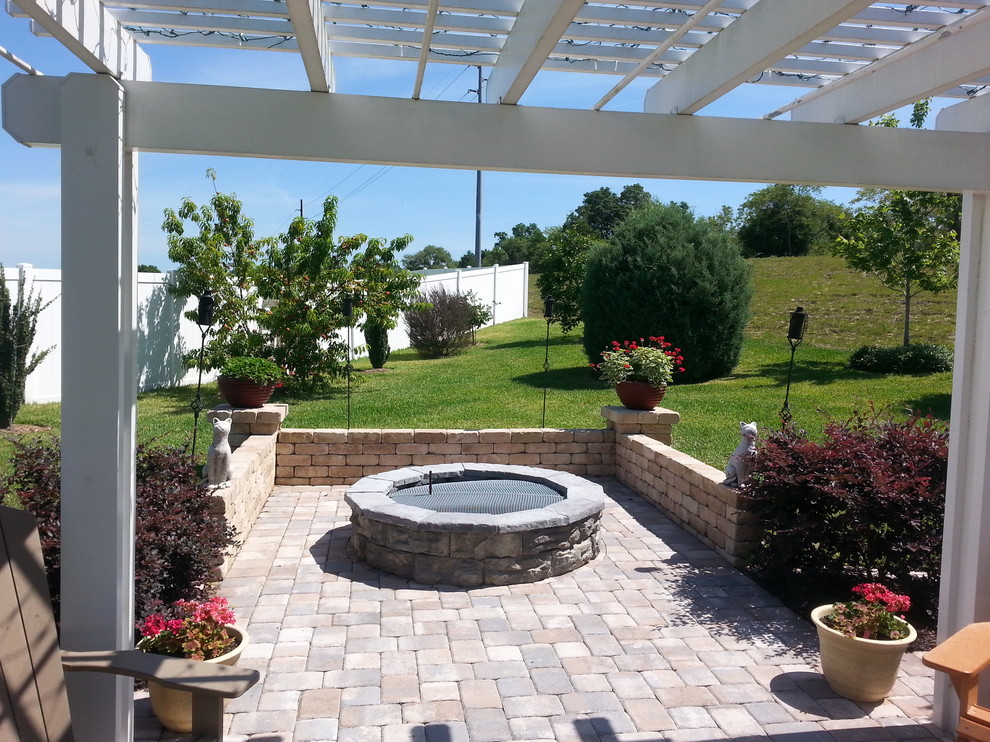 Large traditional backyard patio in Orlando with concrete pavers, a pergola and a fire feature.