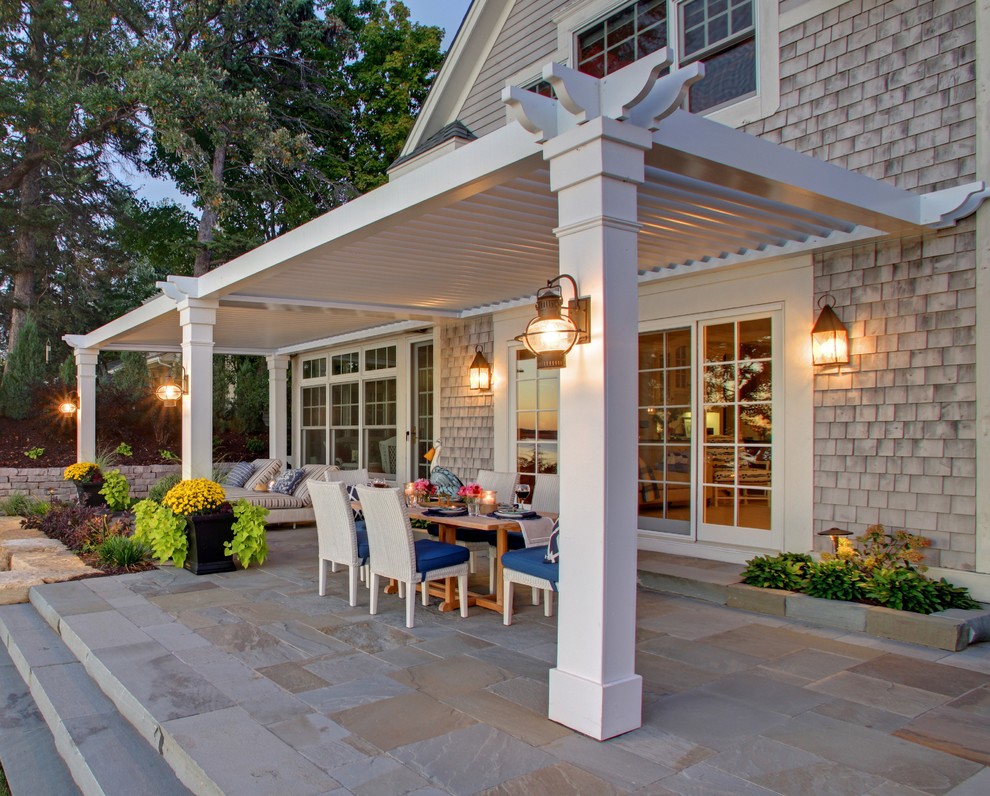 This is an example of a large traditional backyard patio in New York with a pergola.