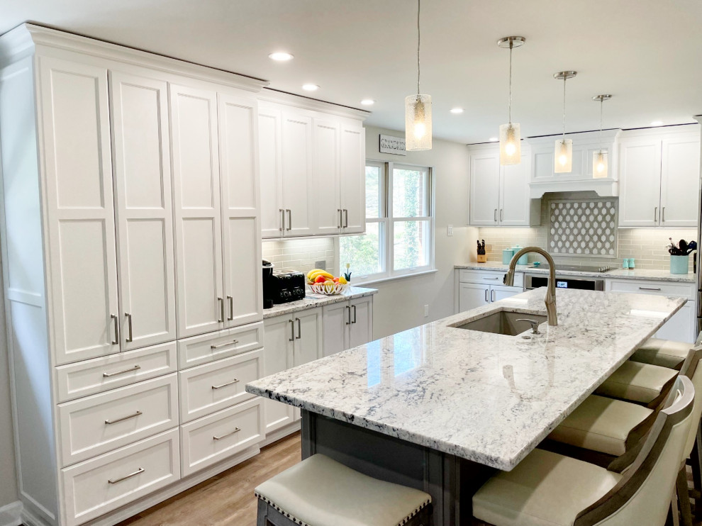 Kitchen - mid-sized transitional kitchen idea with an undermount sink, recessed-panel cabinets, white cabinets, granite countertops, gray backsplash, stainless steel appliances and white countertops