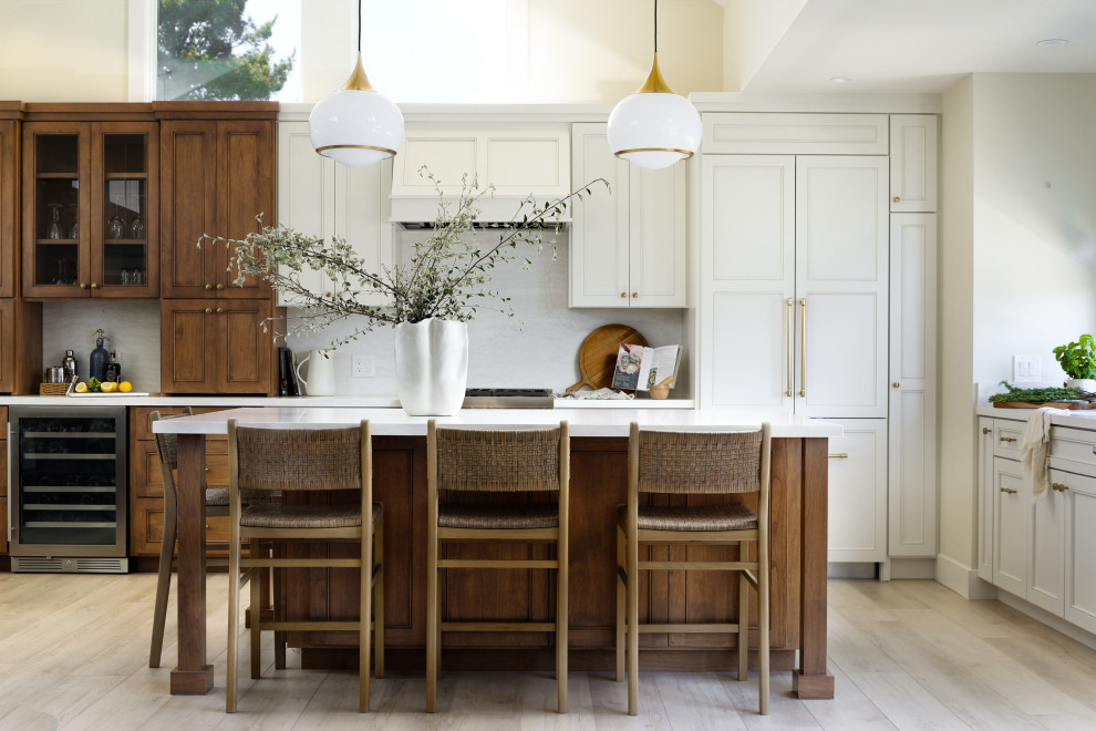 Kitchen - coastal l-shaped light wood floor and beige floor kitchen idea with recessed-panel cabinets, white cabinets, paneled appliances, an island and white countertops
