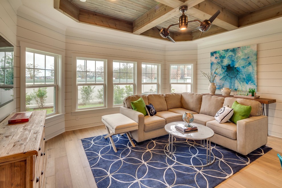 This is an example of a large arts and crafts open concept family room in Miami with white walls, light hardwood floors, no fireplace and a wall-mounted tv.
