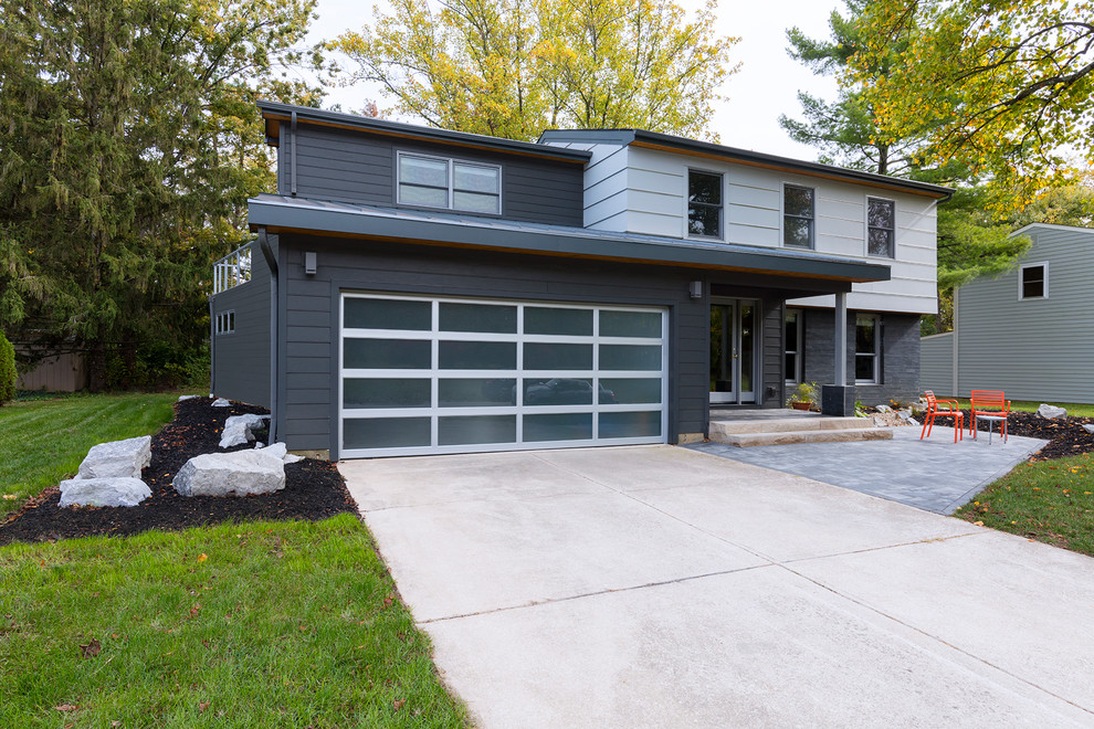 Mid-sized contemporary two-storey grey house exterior in Columbus with vinyl siding, a gable roof and a metal roof.