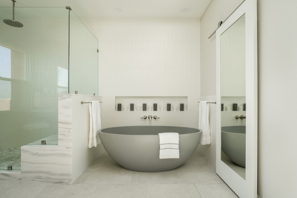Large modern master bathroom in Orange County with flat-panel cabinets, light wood cabinets, a freestanding tub, white tile, porcelain tile, porcelain floors, an undermount sink, marble benchtops, white benchtops, a double vanity and a built-in vanity.
