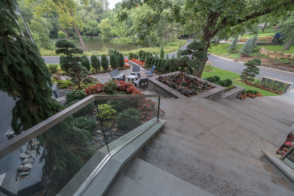 Photo of an expansive contemporary sloped full sun formal garden for summer in Minneapolis with a garden path and natural stone pavers.