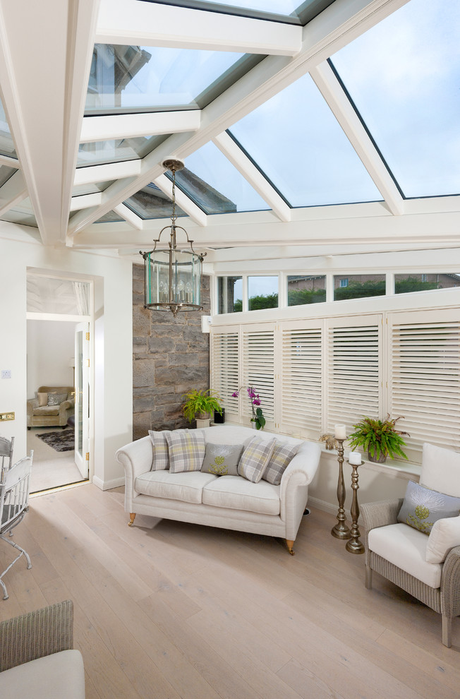 Photo of a large modern sunroom in Glasgow with travertine floors, a glass ceiling and grey floor.