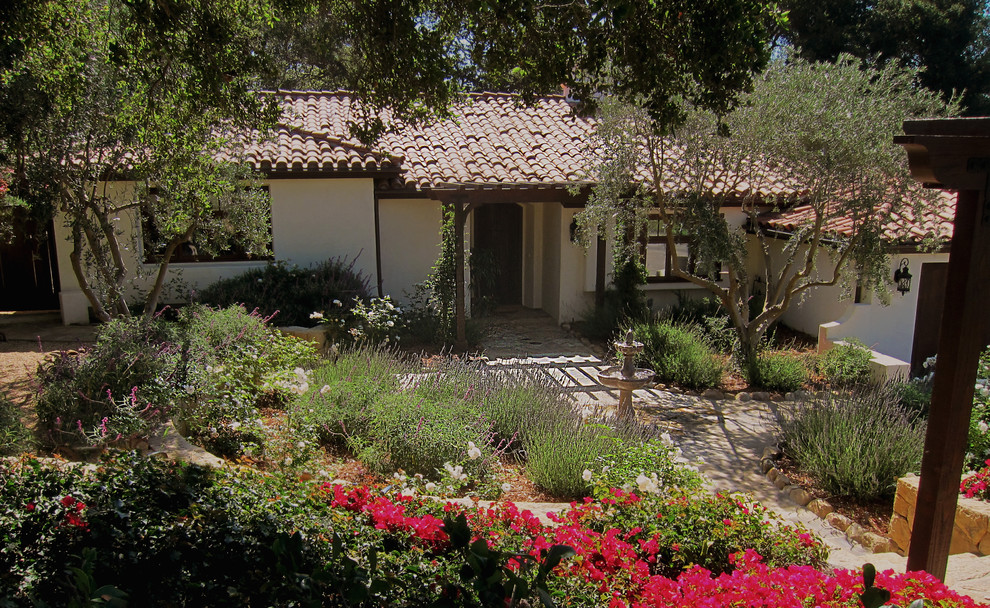 Design ideas for a mid-sized mediterranean front yard full sun xeriscape for summer in Santa Barbara with a garden path and natural stone pavers.