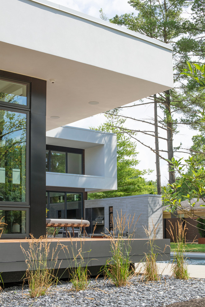 Example of a minimalist white two-story wood flat roof design in Indianapolis with a green roof