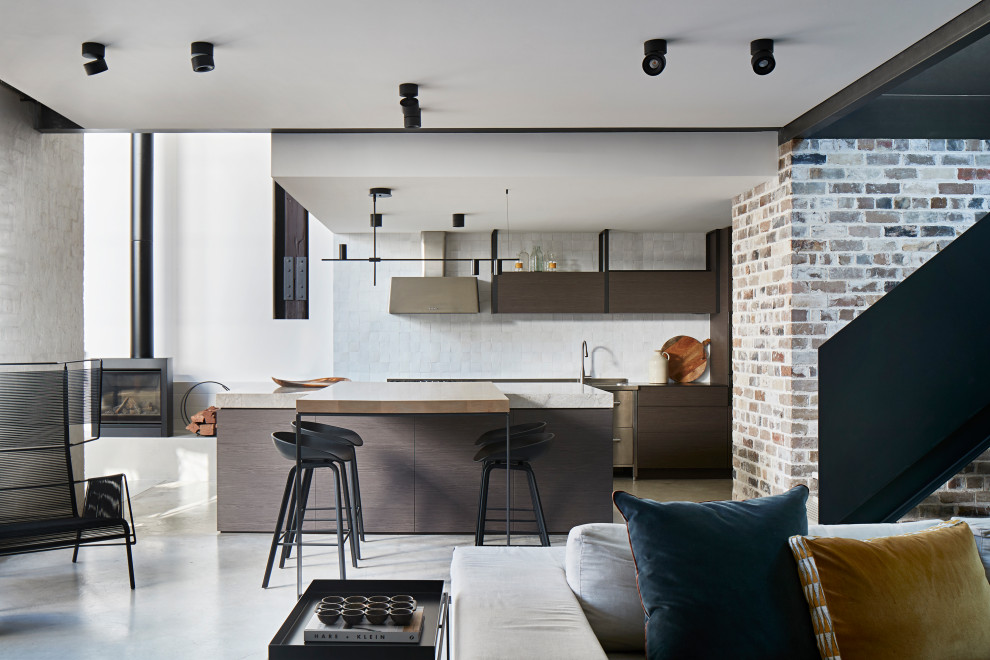 Industrial open plan kitchen in Sydney with flat-panel cabinets, brown cabinets, white splashback, concrete floors, with island, grey floor and white benchtop.