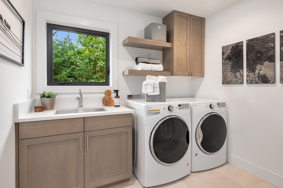Mid-sized transitional single-wall beige floor and travertine floor dedicated laundry room photo in Seattle with an undermount sink, shaker cabinets, white walls, a side-by-side washer/dryer, white countertops and light wood cabinets