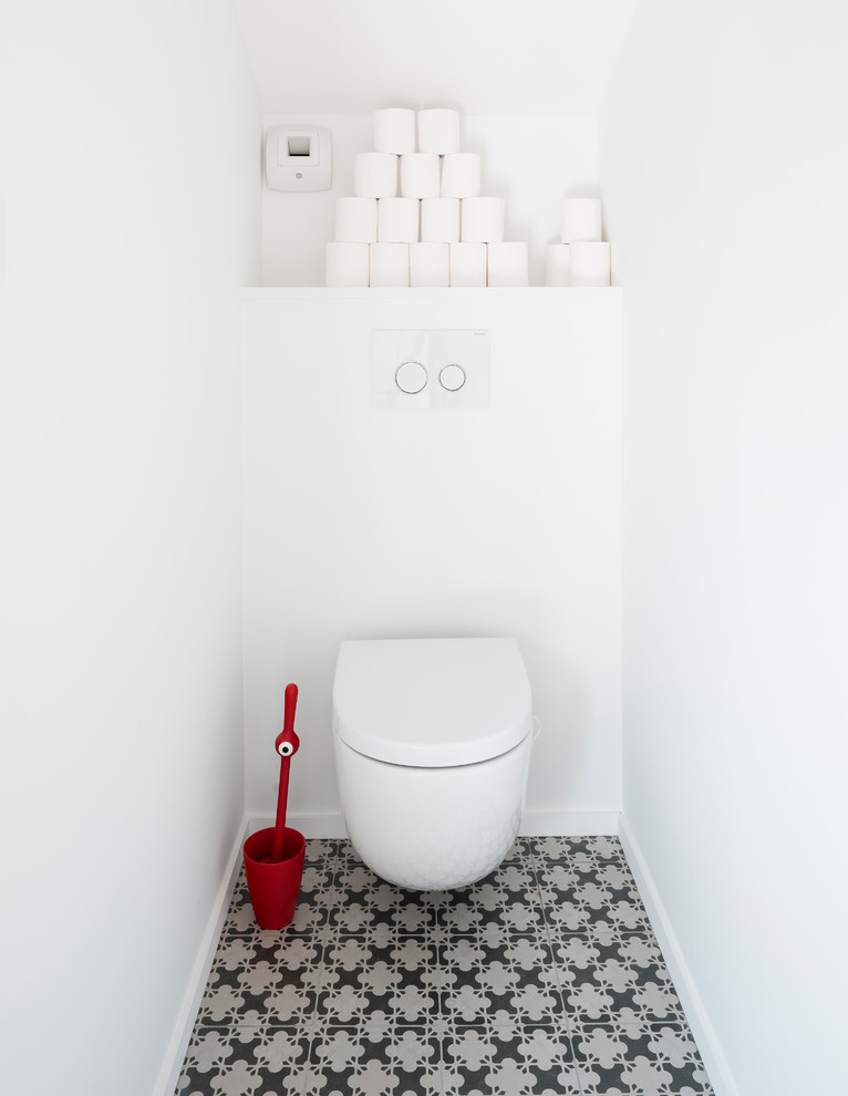 Design ideas for a mid-sized contemporary powder room in Nantes with a wall-mount toilet, white walls and ceramic floors.