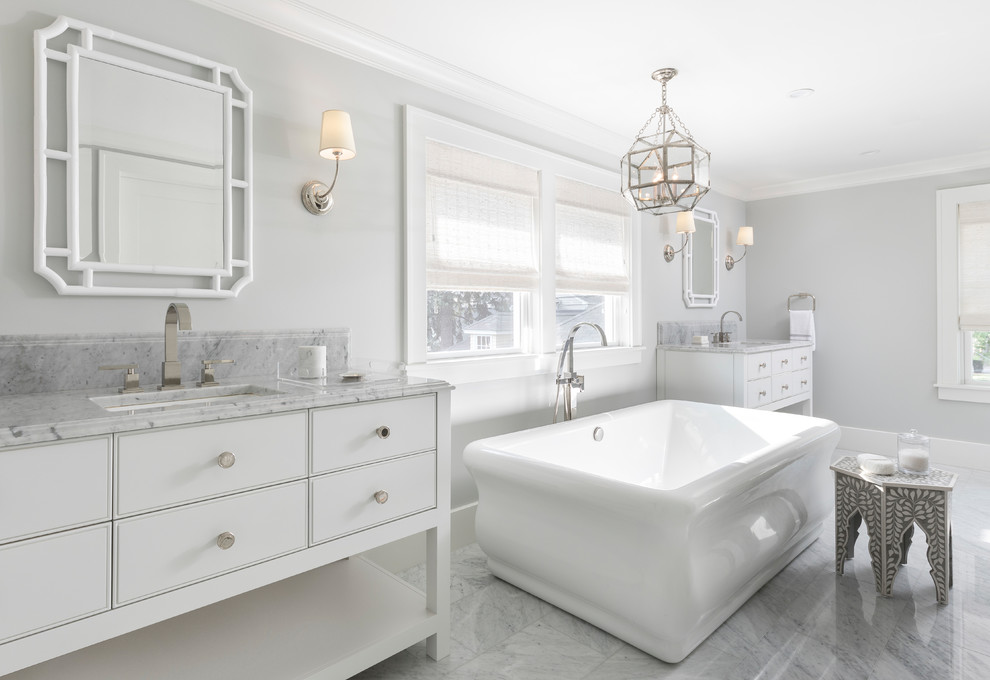 Inspiration for a transitional master bathroom in Detroit with white cabinets, a freestanding tub, grey walls, marble floors, an undermount sink, marble benchtops, grey floor, grey benchtops and flat-panel cabinets.