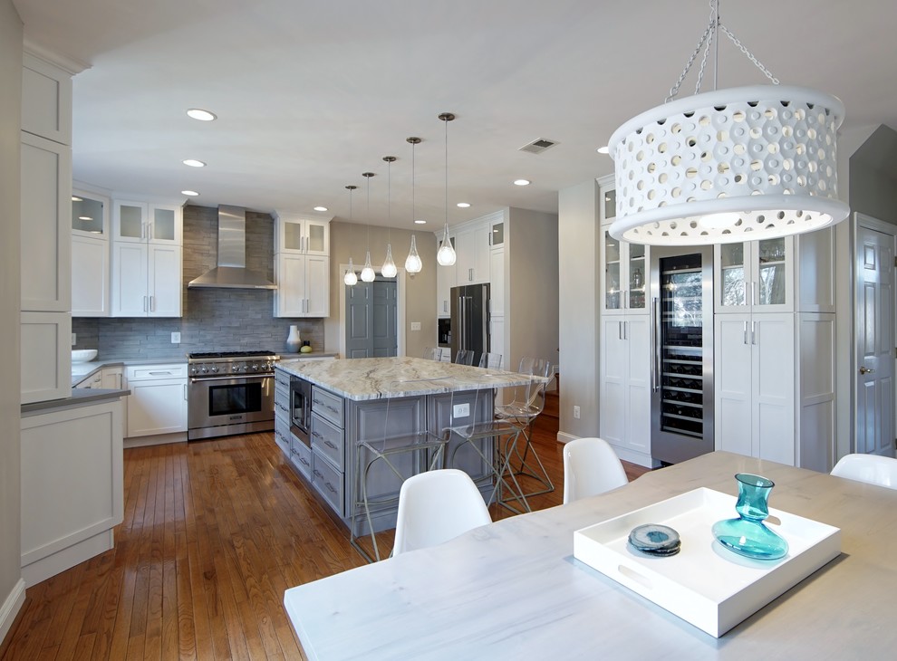 Transitional u-shaped open concept kitchen photo in DC Metro with an undermount sink, shaker cabinets, white cabinets, quartz countertops, gray backsplash, porcelain backsplash, stainless steel appliances and an island