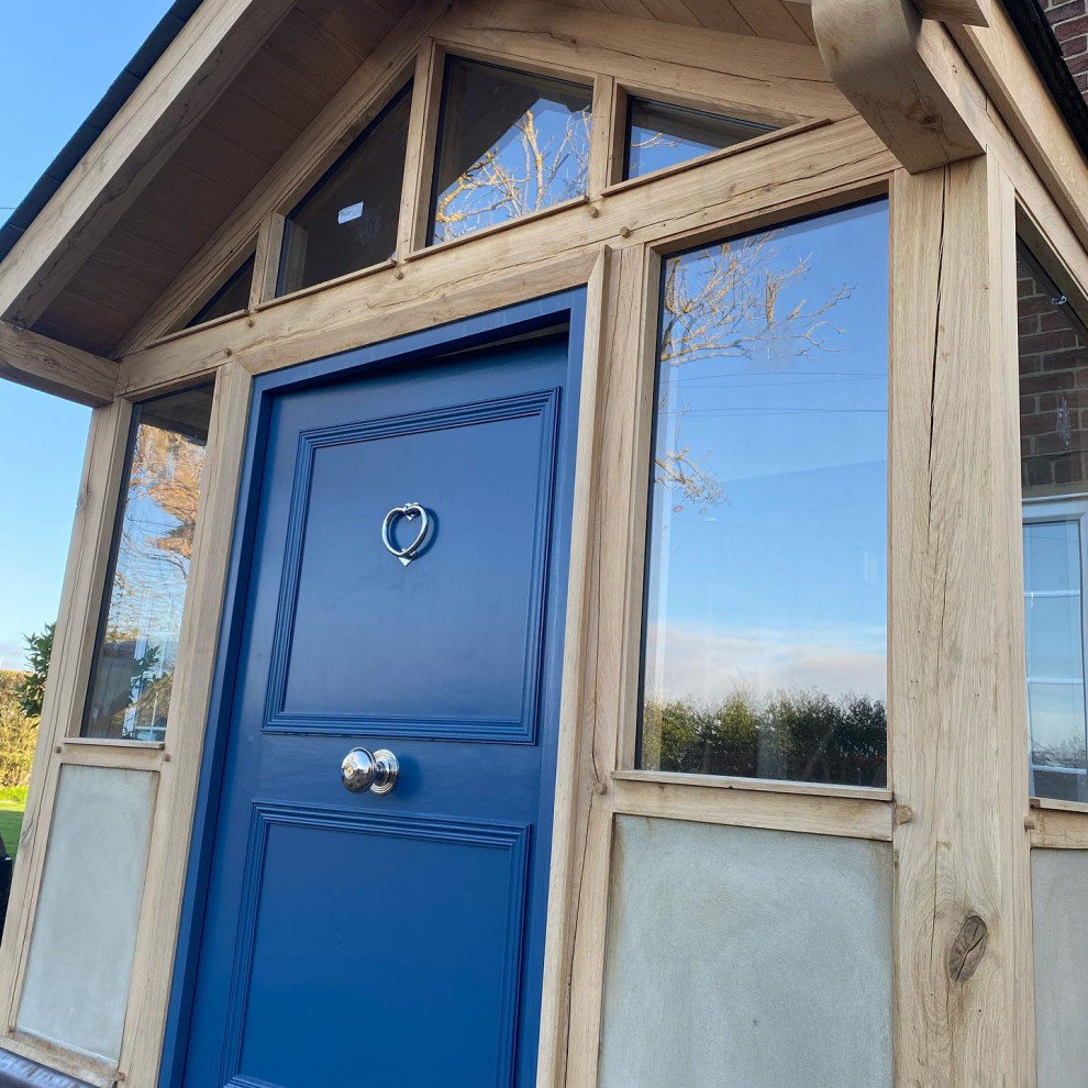 Foto på en stor vintage ingång och ytterdörr, med en enkeldörr och en blå dörr