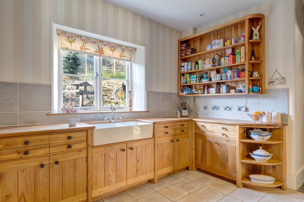 This is an example of a country u-shaped kitchen in Devon with a farmhouse sink, open cabinets, medium wood cabinets, wood benchtops and grey splashback.