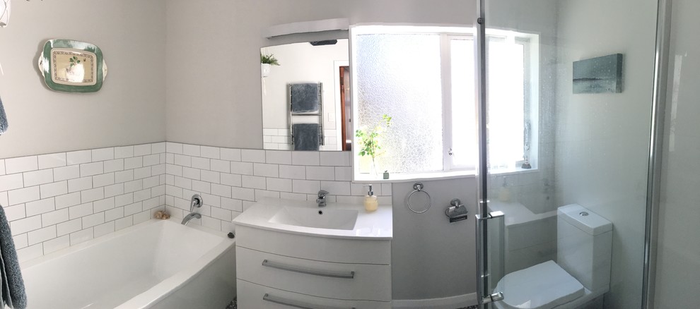 Inspiration for a small eclectic master bathroom in Wellington with white cabinets, an alcove tub, a corner shower, a one-piece toilet, white tile, ceramic tile, white walls, linoleum floors, an integrated sink, marble benchtops, blue floor and a hinged shower door.