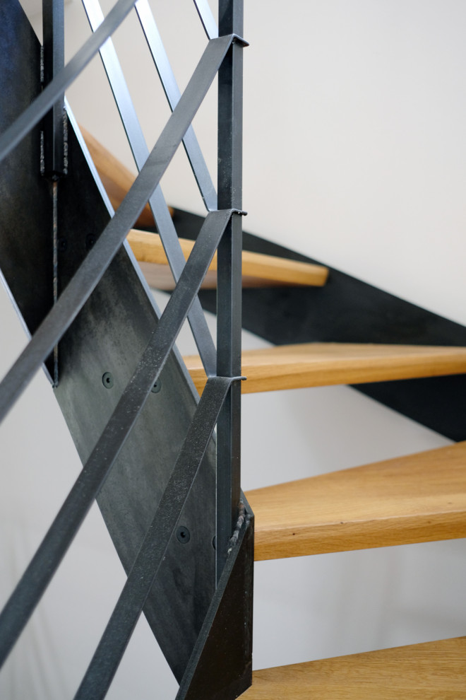 Стильный дизайн: изогнутая лестница в стиле лофт с деревянными ступенями и металлическими перилами - последний тренд