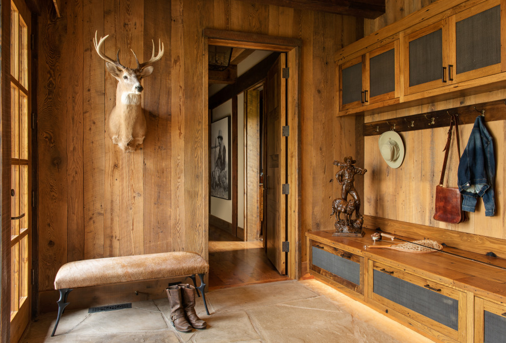 Example of a large transitional slate floor, beige floor, exposed beam and wood wall mudroom design with brown walls and a brown front door
