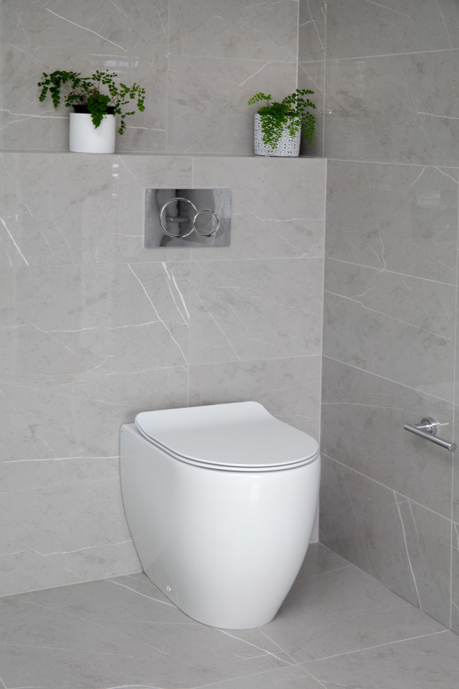 Réalisation d'une grande salle de bain principale minimaliste avec WC suspendus, un carrelage gris, des carreaux de céramique, un mur gris, un sol en carrelage de céramique et un sol gris.