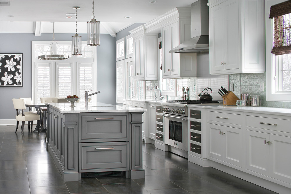 Photo of a transitional galley eat-in kitchen in New York with beaded inset cabinets, white cabinets, stainless steel appliances, with island, grey splashback and white benchtop.