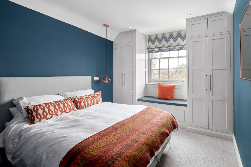 Design ideas for a mid-sized transitional master bedroom in West Midlands with blue walls, carpet and grey floor.